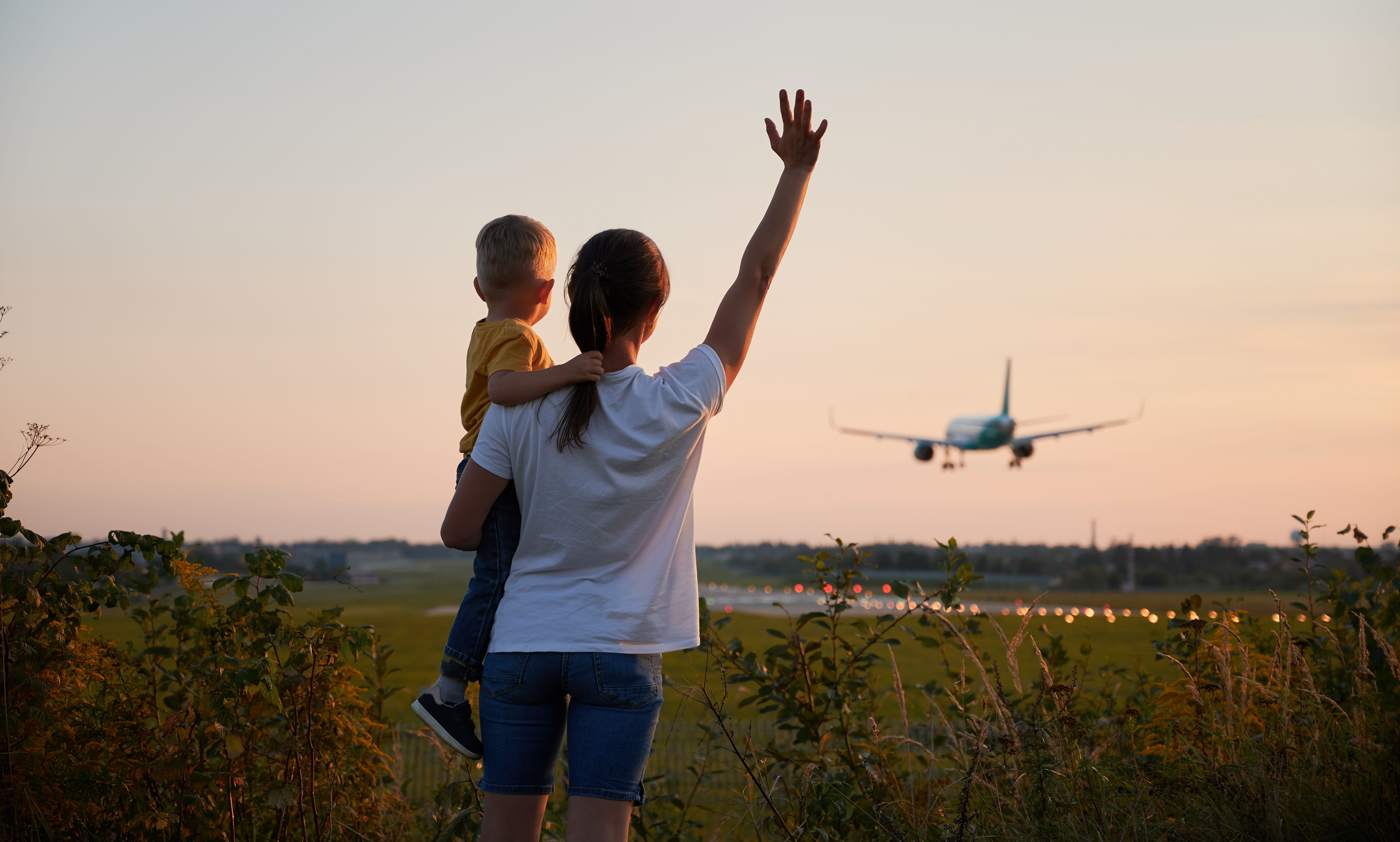 Back,View,Of,Woman,With,Kid,Waving,Hands,To,Landing » Tembo Travel fly der lander