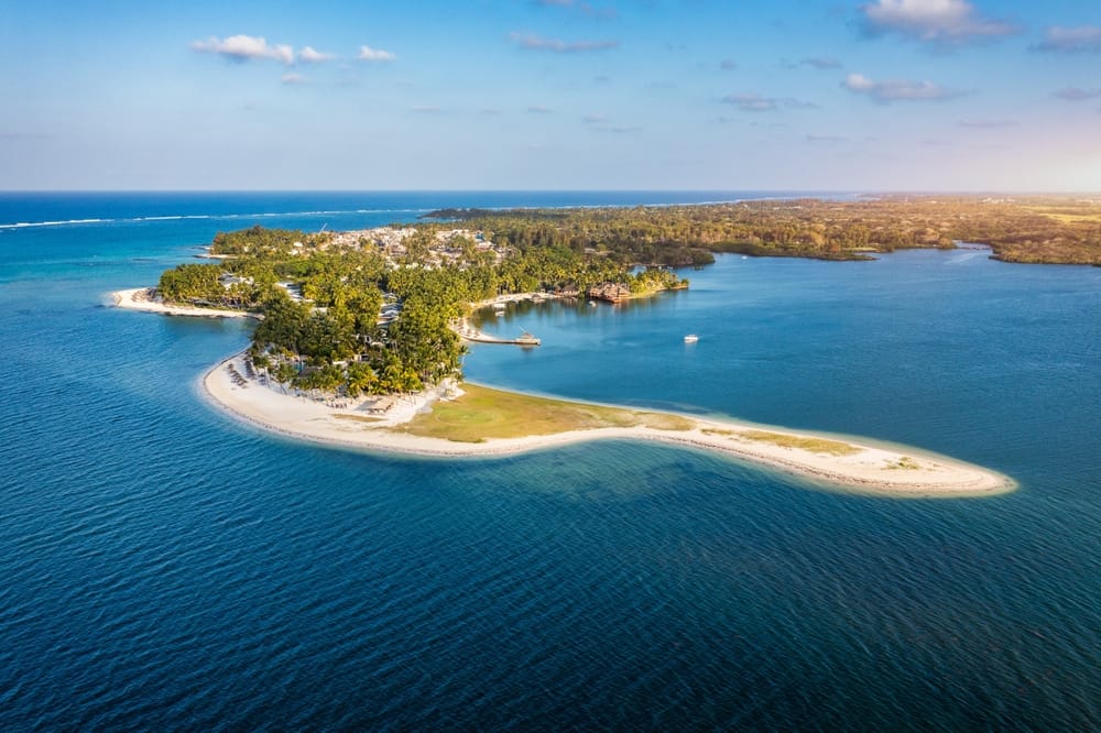 Dronefoto over stranden ved Constance Belle Mare på Mauritius – panorama af hvidt sand, turkisblåt hav og tropiske omgivelser.