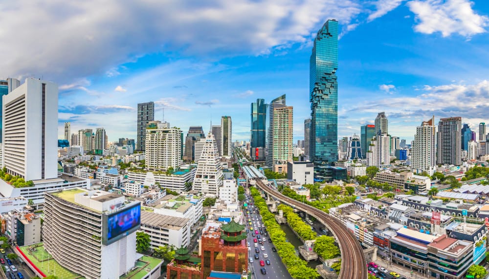Byudsigt over Bangkok med moderne skyline og en travl metrostation. Kombinationen af højhuse, byliv og effektiv offentlig transport viser Thailands hovedstad som et dynamisk rejsemål, hvor tradition og modernitet mødes.