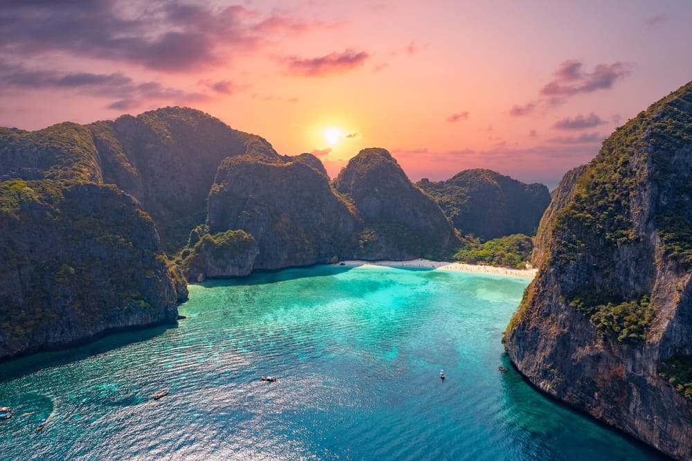 Luftfoto i topview af den tropiske ø Phi Phi Leh med den berømte Maya Bay. Smaragdgrønt hav, kalkstensklipper og hvid sandstrand danner et paradisisk landskab – et ikonisk rejsemål i Thailand kendt fra filmen “The Beach”.