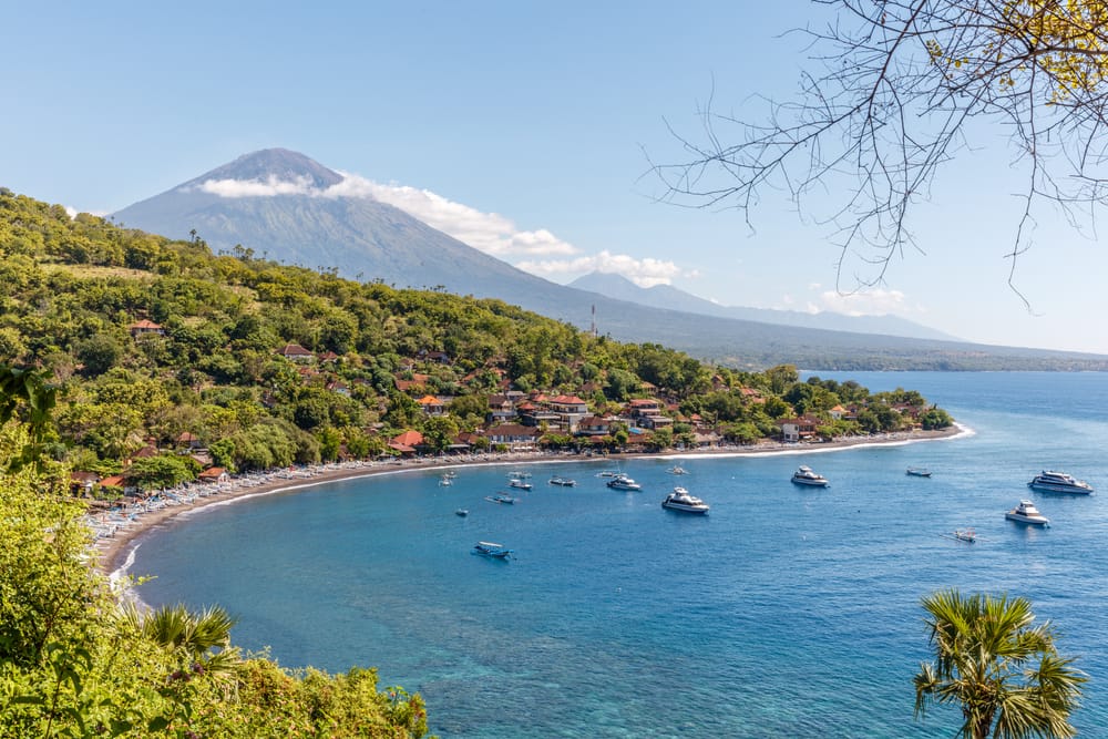 Udsigt over Agung-vulkanen fra havet – traditionelle landsbyer og huse ved kysten på Bali, Indonesien. Udsigt over Agung-vulkanen fra havet – traditionelle landsbyer og huse ved kysten på Bali, Indonesien.