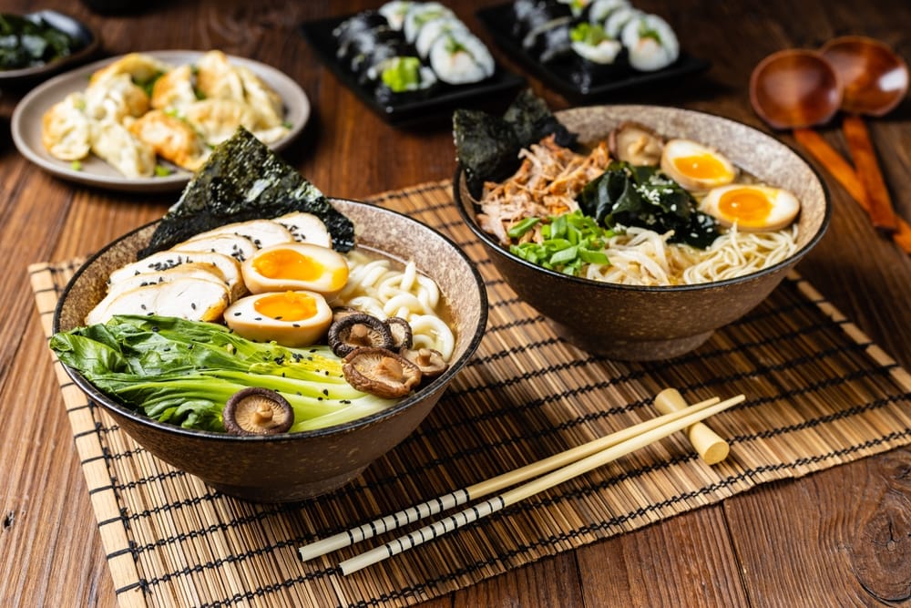 En skål dampende ramen serveret med udon-nudler og toppet med mørt marineret svinekød eller kylling – en klassisk japansk smagsoplevelse.