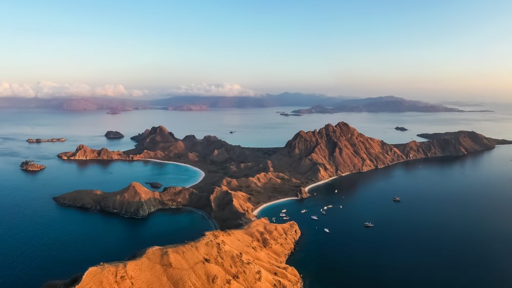 Panoramisk udsigt over Padar-øen i Komodo-øerne, Flores, Indonesien – dramatisk tropisk ølandskab med klipper, strande og turkisblåt hav. Panoramisk udsigt over Padar-øen i Komodo-øerne, Flores, Indonesien – dramatisk tropisk ølandskab med klipper, strande og turkisblåt hav.
