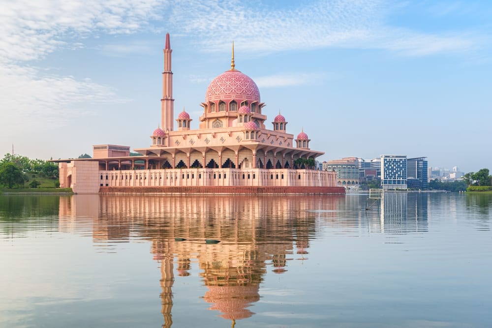 Fantastisk udsigt over Putra-moskeen ved solopgang i Putrajaya, Malaysia – imponerende arkitektur omgivet af roligt vand og farverig himmel. » Tembo Travel Fantastisk udsigt over Putra-moskeen ved solopgang i Putrajaya, Malaysia – imponerende arkitektur omgivet af roligt vand og farverig himmel.