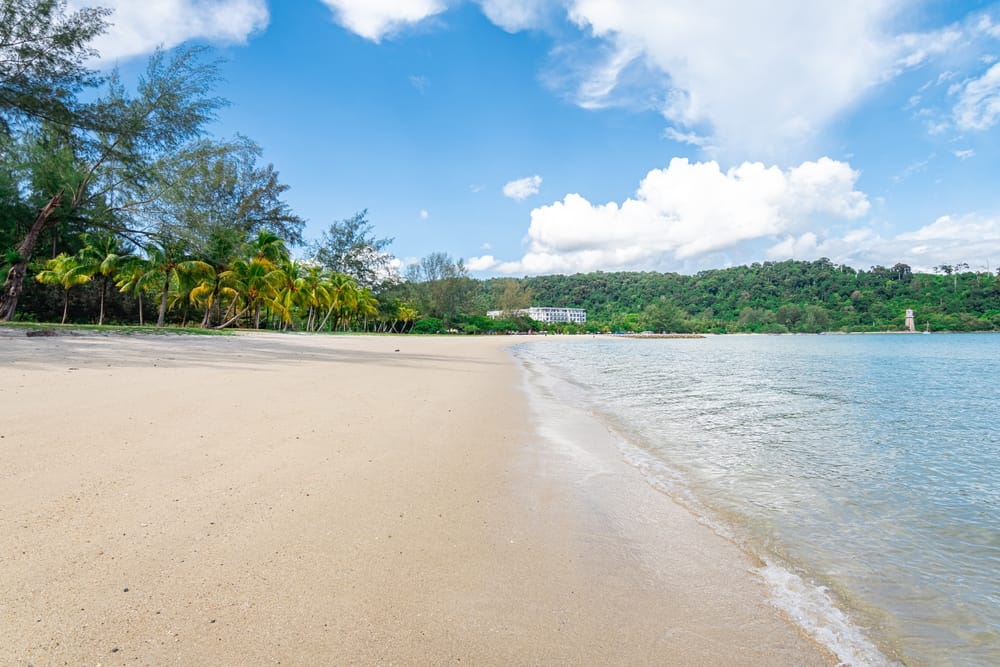 Tom sandstrand på Langkawi Island i Malaysia med klart vand og palmer, et fredeligt tropisk tilflugtssted