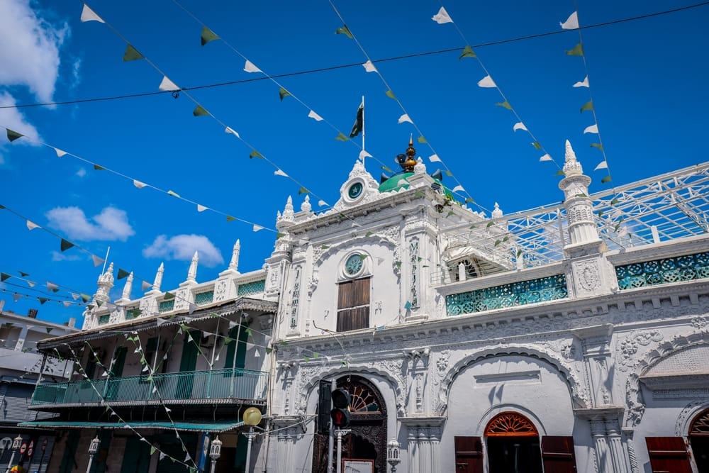 Hvid moské i Port Louis på Mauritius med klassisk islamisk arkitektur og detaljerige facader.
