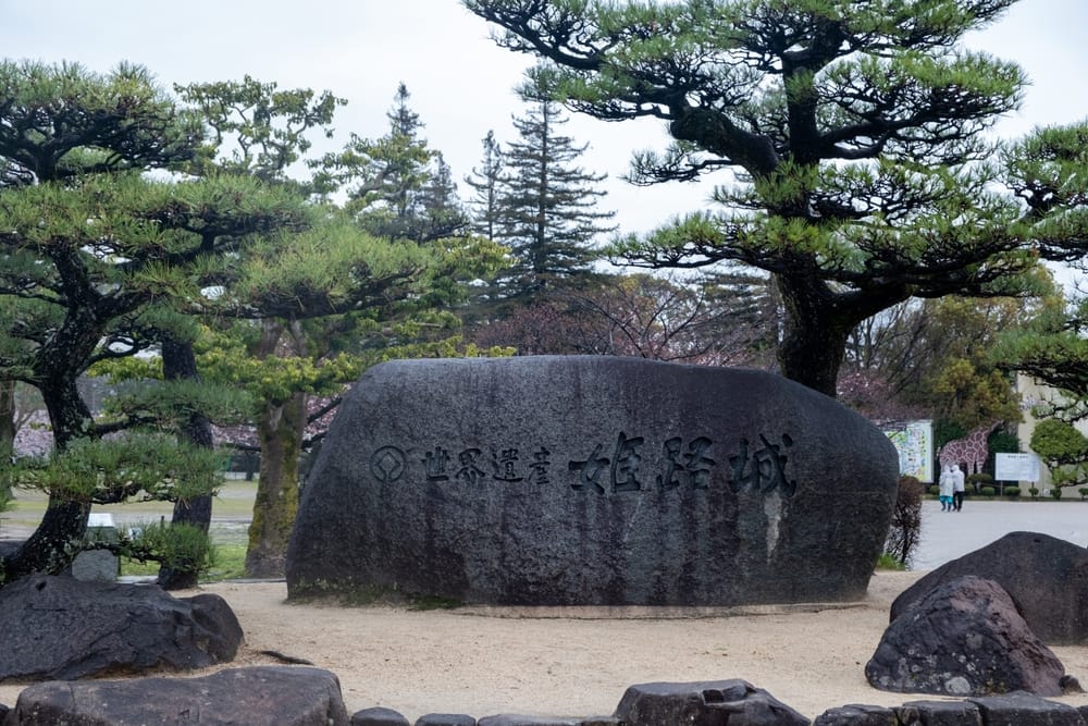 Stor sten med indgraveret skrift ved indgangen til Himeji Slot i Japan, som markerer slottets historiske betydning