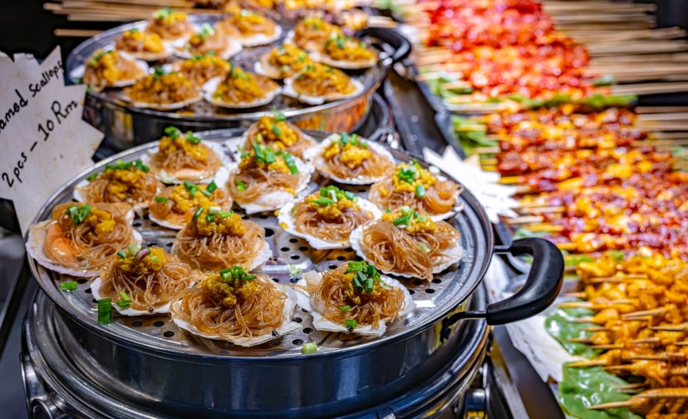 Gadeboder med street food på Jalan Alor-markedet i Bukit Bintang, Kuala Lumpur, kendt for sit livlige natteliv og kulinariske oplevelser