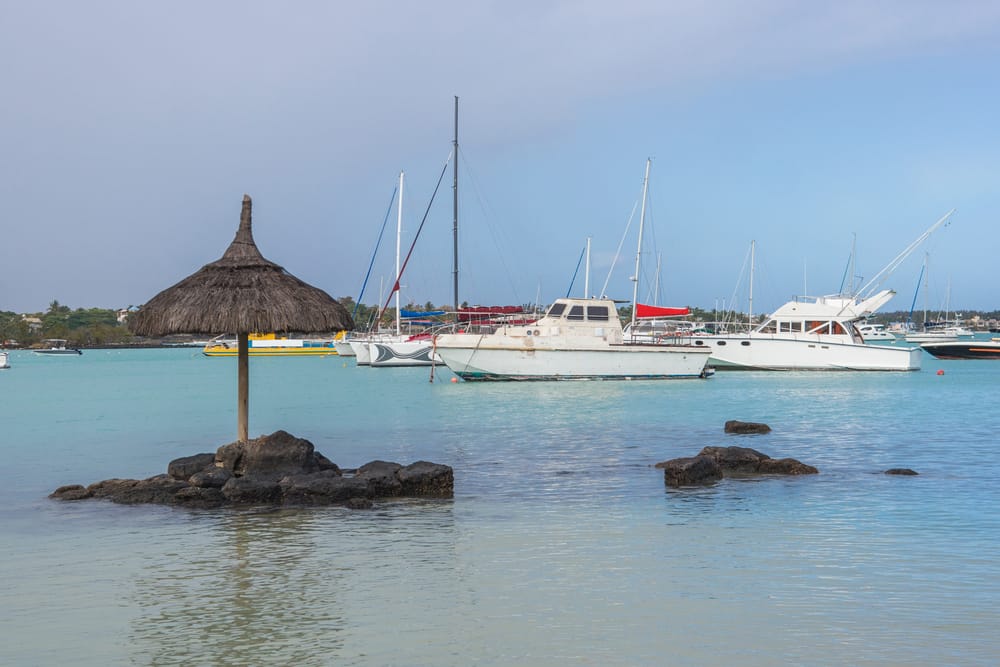 Farverige fiskerbåde vugger på det rolige vand ved Grand Baie – en autentisk kystby på Mauritius med lokal charme og tropisk stemning. » Tembo Travel Farverige fiskerbåde vugger på det rolige vand ved Grand Baie – en autentisk kystby på Mauritius med lokal charme og tropisk stemning.