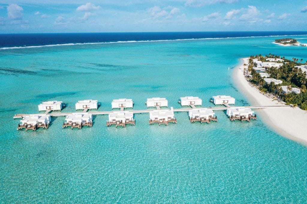 Overwater-villaer set fra luften på RIU Atoll i turkis lagune.
