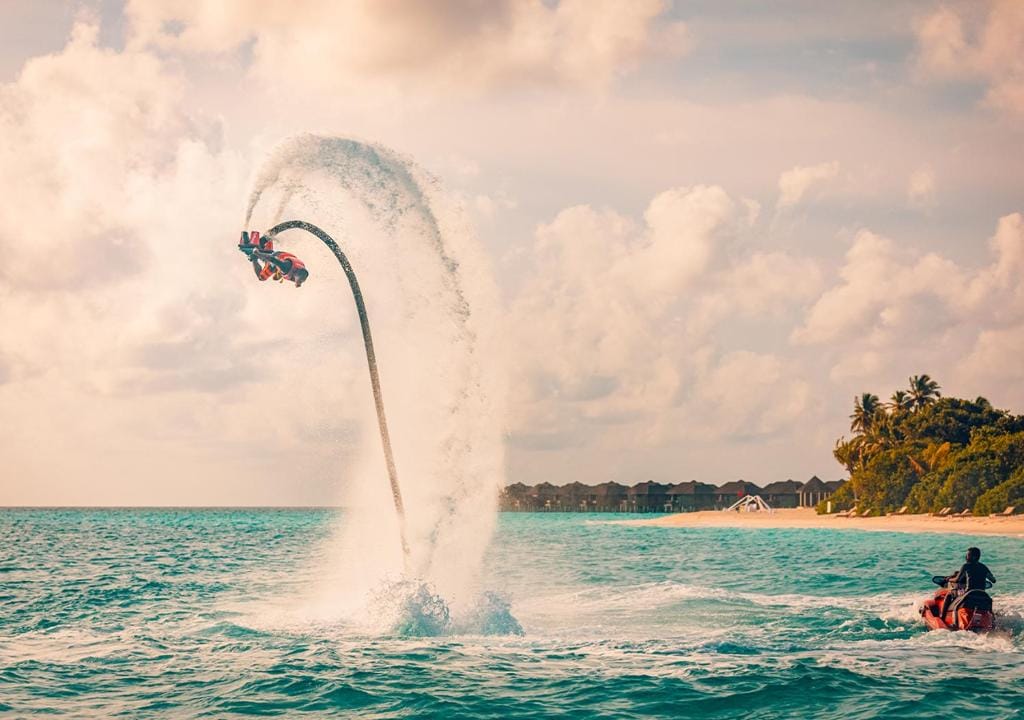 Person der laver flyboarding over havet ved Sun Siyam Iru Fushi på Maldiverne.