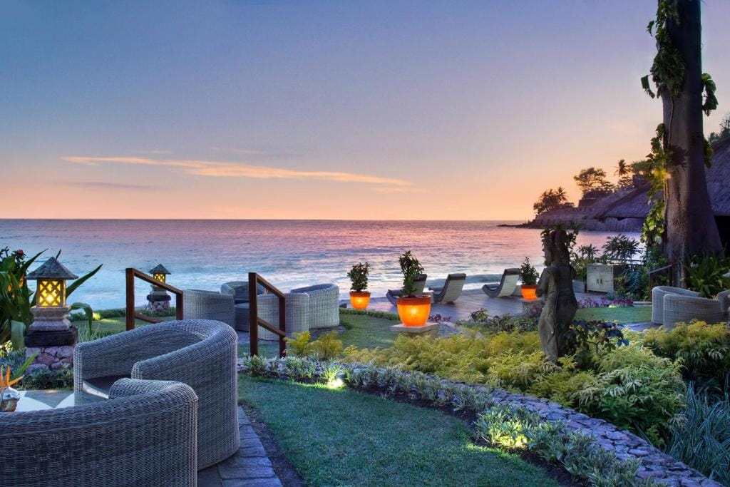 Solnedgang ved Sheraton Senggigi Beach Resort, Lombok, Indonesien, med loungeområde, lanterner og udsigt over havet.