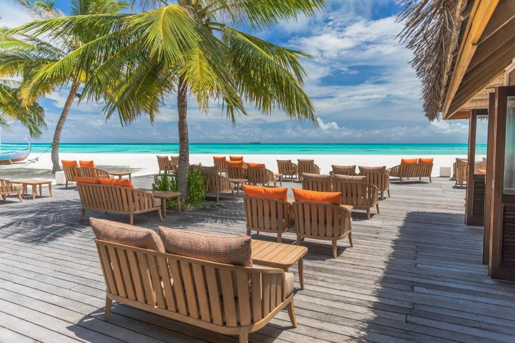 Strandlounge med træmøbler og udsigt over havet på Meeru Island