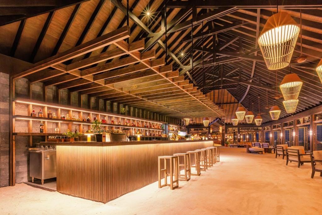 Luksuriøs resortbar med moderne trædesign på Jawakara Maldiverne.