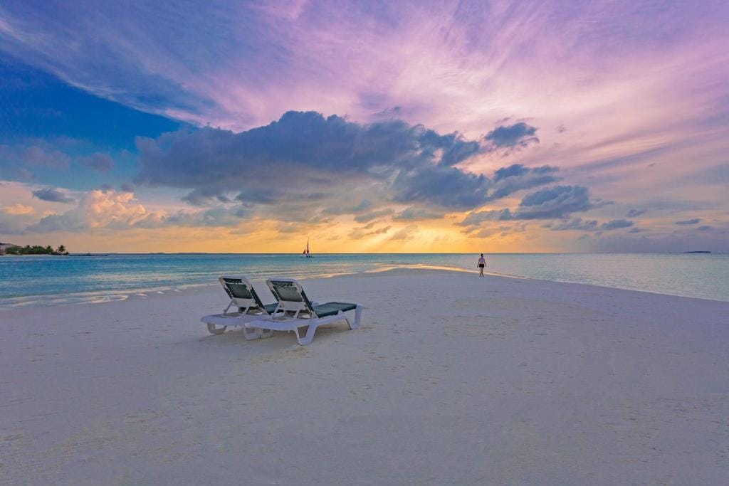 Solnedgang over sandbanke med strandstole på Meeru Island