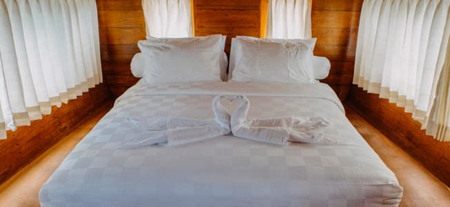 Master Cabin på White Pearl 02 liveaboard, Komodo National Park, Indonesien – luksuriøs kahyt med dobbeltseng og havudsigt.