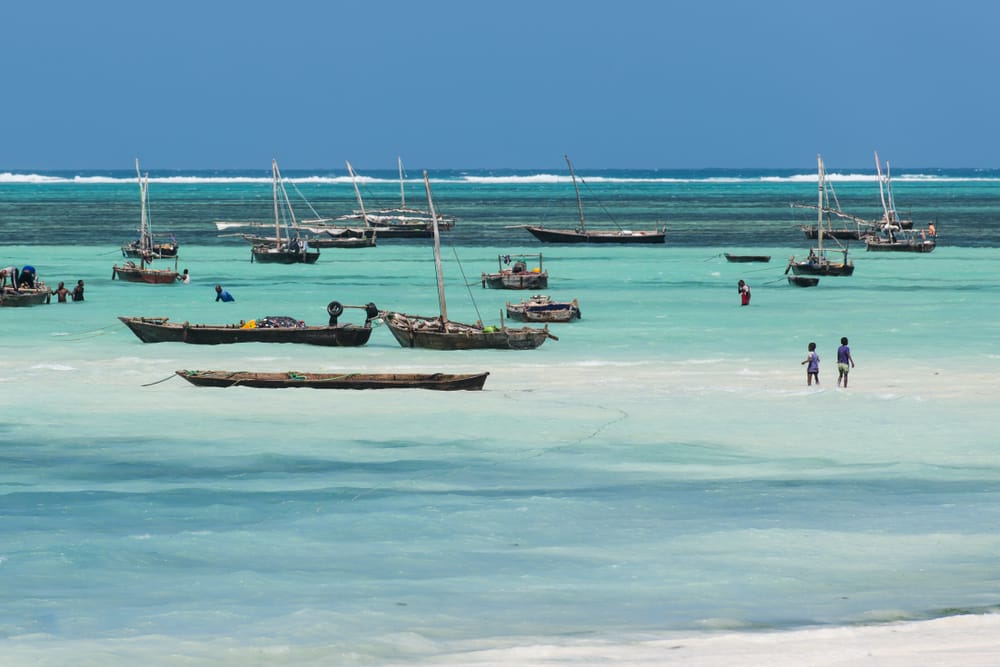 Børn leger i vandkanten på Nungwi Beach på Zanzibar en solrig dag.