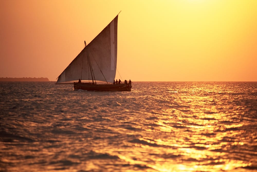 En dhow i silhuet på Det Indiske Ocean ved solnedgang ud for Zanzibar.