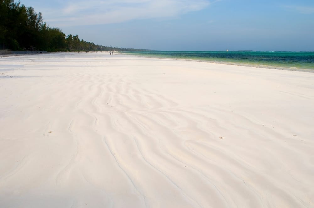 Matemwe Beach på Zanzibar med fint hvidt sand og svajende palmer – en rolig strand ved det klare, turkisblå hav.