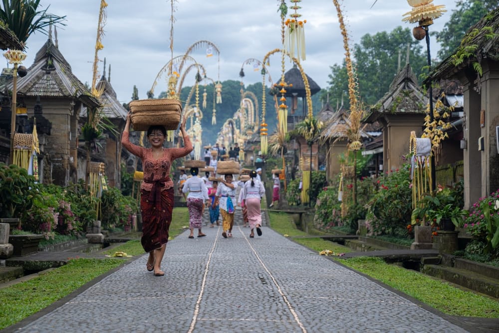 Traditionel balinesisk landsby, Penglipuran Village, på Østbali med stenbelagt hovedgade, farverige blomster og traditionelle huse.
