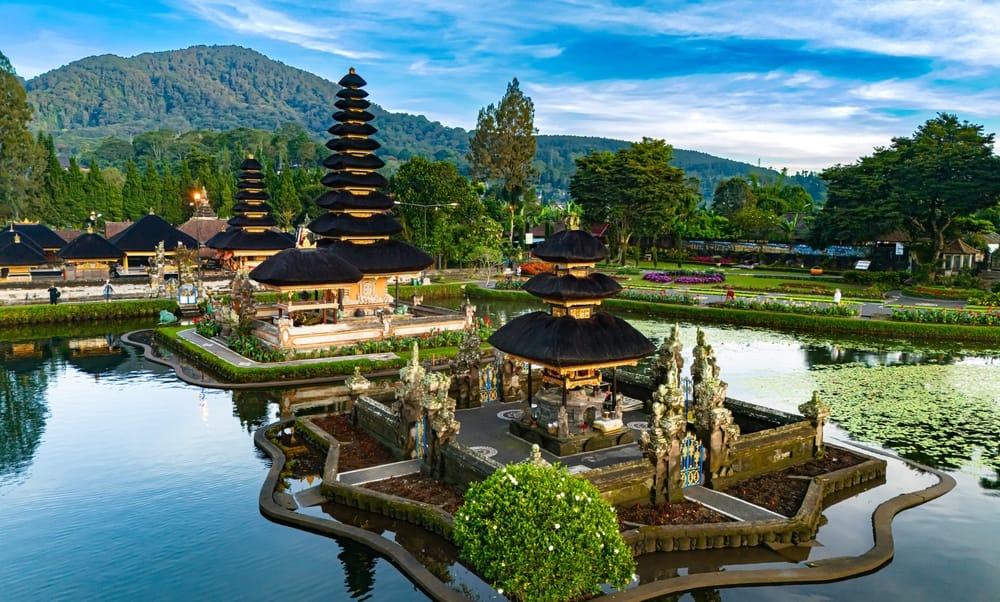 Ulun Danu Beratan-templet ved bredden af Lake Bratan på Bali – et ikonisk vandtempel omgivet af tågedækkede bjerge og spejlblankt vand.
