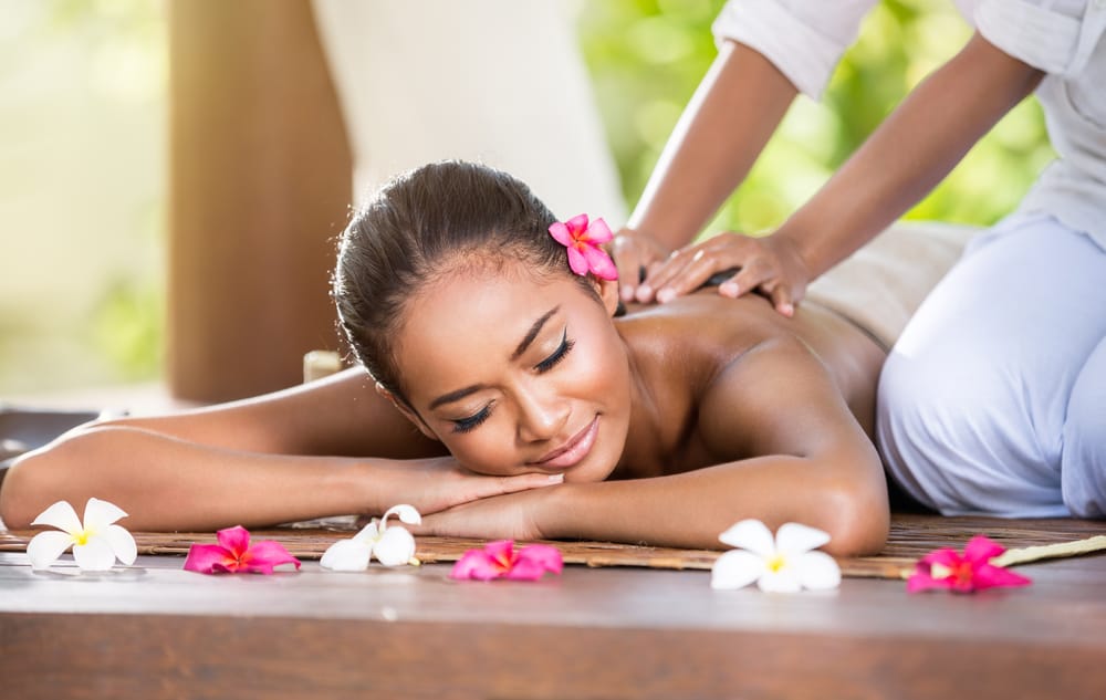 Smilende kvinde får rygmassage på spa i Bali, Indonesien.