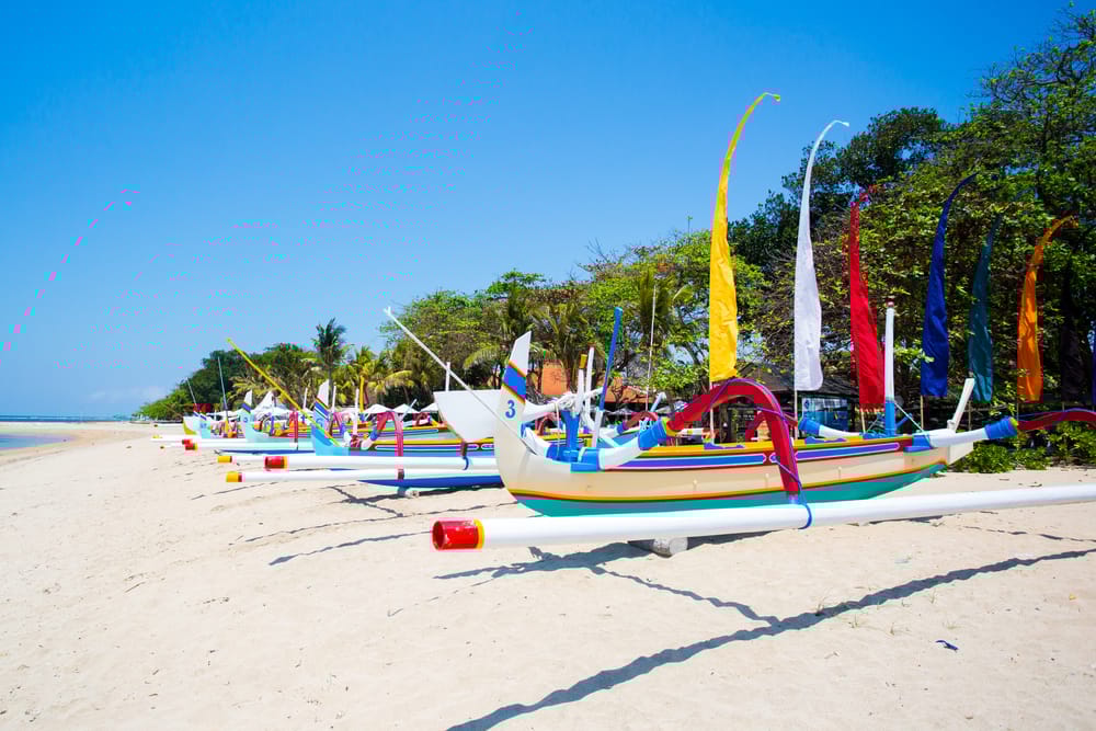Traditionel balinesisk jukung-båd ved Sanur Beach – klar til at sejle ud i det rolige, turkise morgenhav.