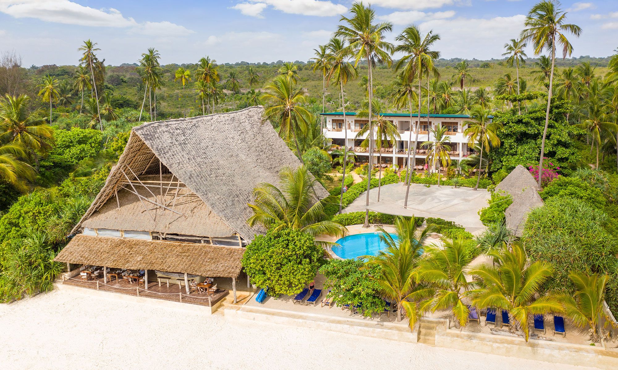 Udsigt over Zanzibar Magic Boutique Hotel ved Matemwe Beach med palmer, hvid sandstrand og turkisblåt hav.