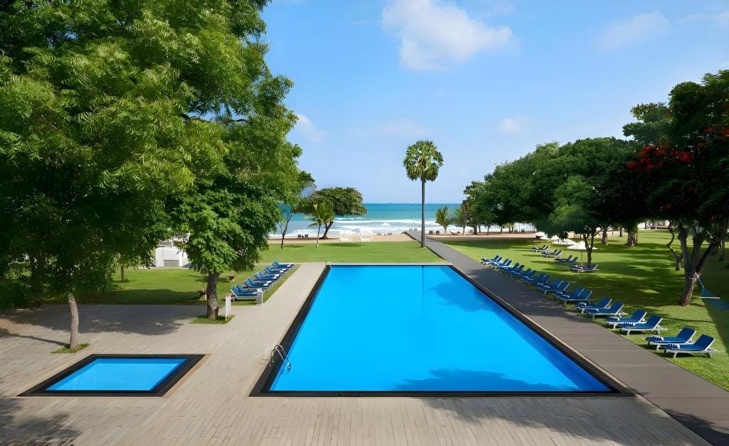Pool og haveområde ved Trinco Blu by Cinnamon i Trincomalee med udsigt til stranden og Det Indiske Ocean.