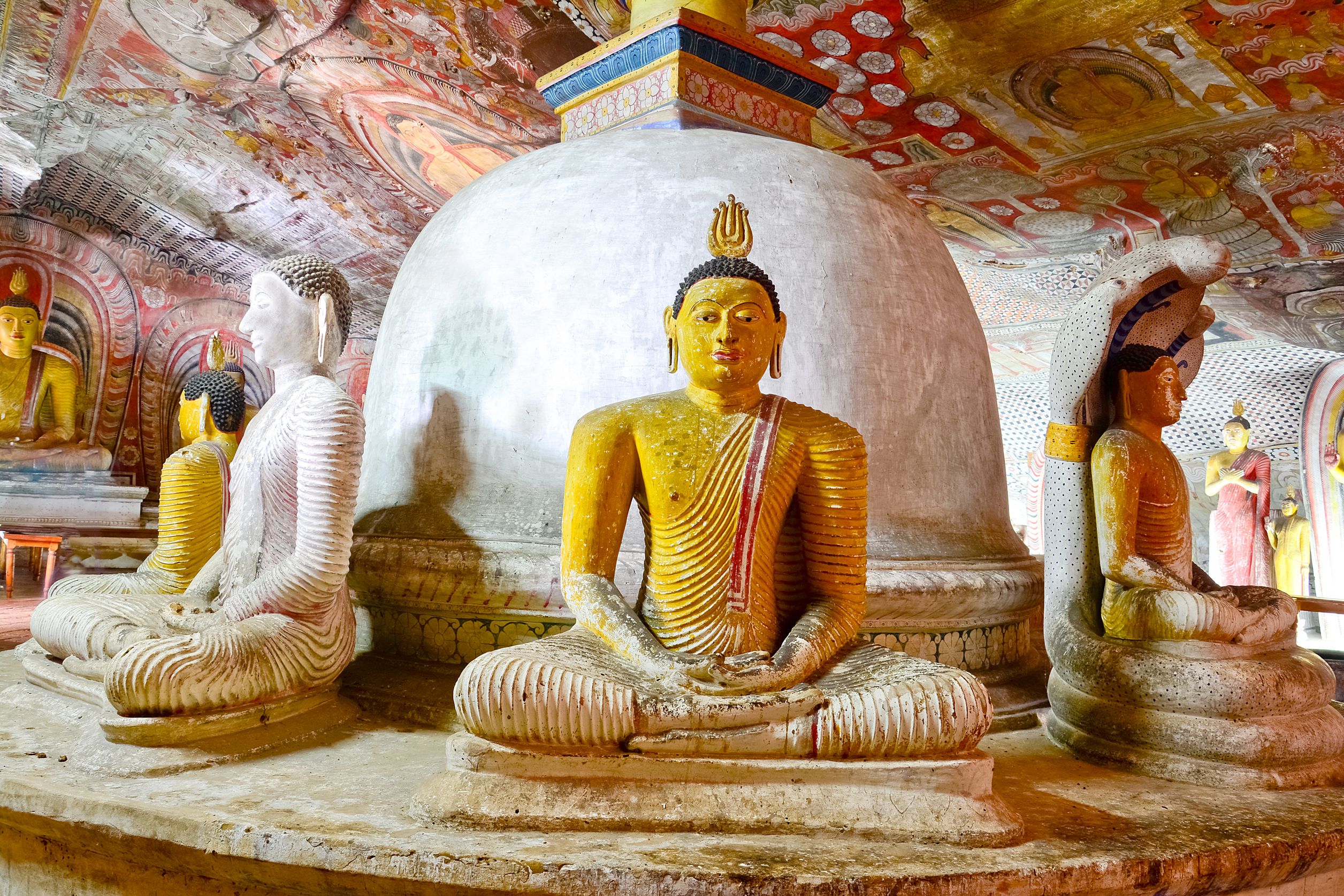 Dambulla Cave Temple et fascinerende hulekompleks hvor vægge og lofter er dækket af detaljerede malerier og rækker af Buddhafigurer skaber en rolig atmosfære dybt inde i klippen