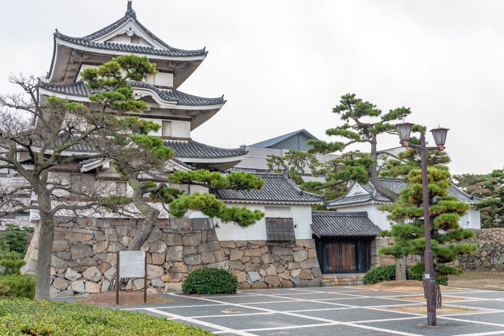 Udsigt over Takamatsu Castle i Japan med stenmure, vandgrave og kig mod Seto-indhavet.