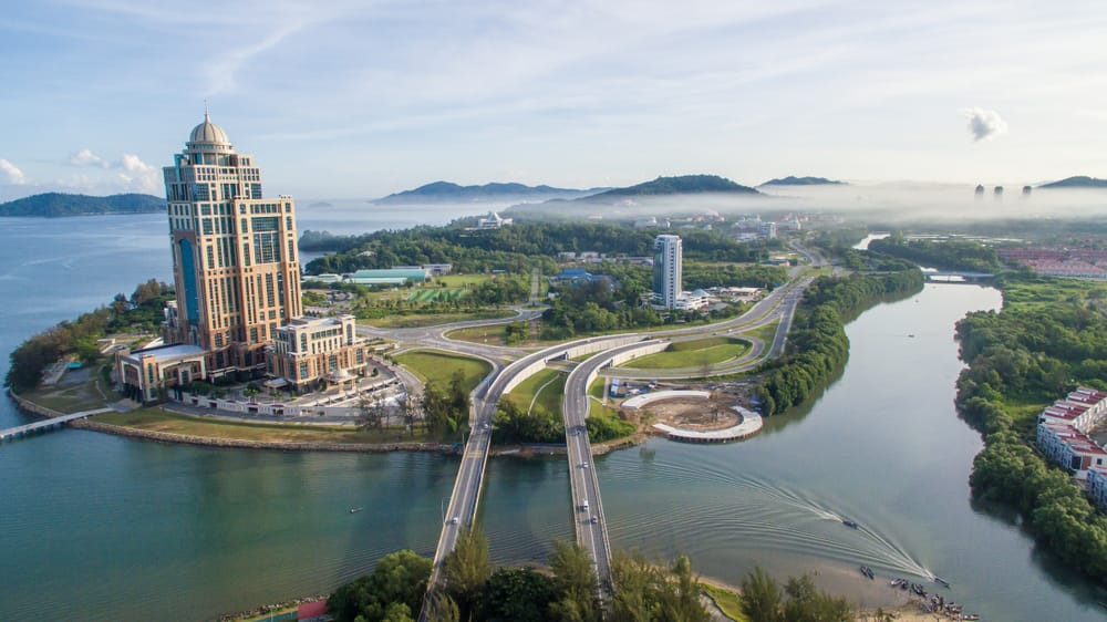 Luftfoto af Kota Kinabalu på Borneo med udsigt over byens skyline, havnefront og det omgivende hav i Sabah.