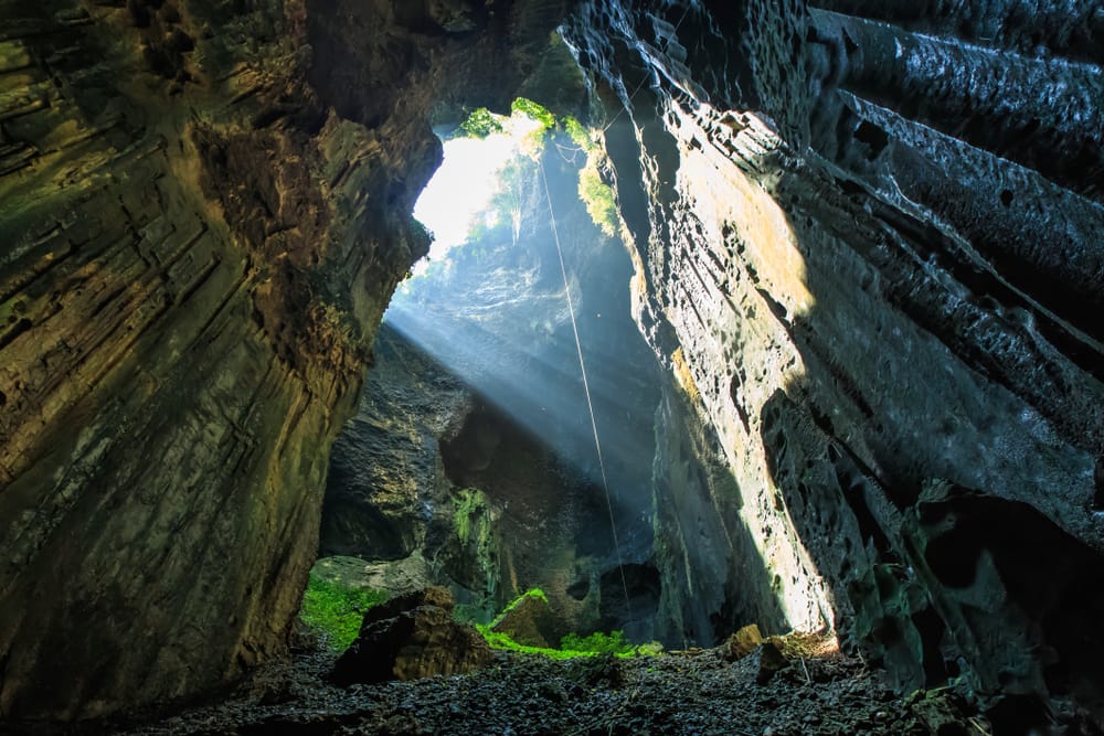 Gomantong Cave i Kinabatangan-distriktet på Borneo, kendt for sine imponerende kalkstensformationer, rige dyreliv og den tætte, omgivende regnskov.