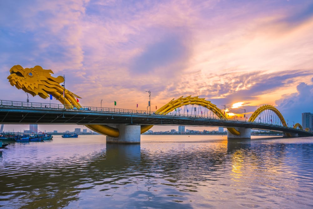 Dragon Bridge i Da Nang badet i gyldne solnedgangsfarver over Han-floden.