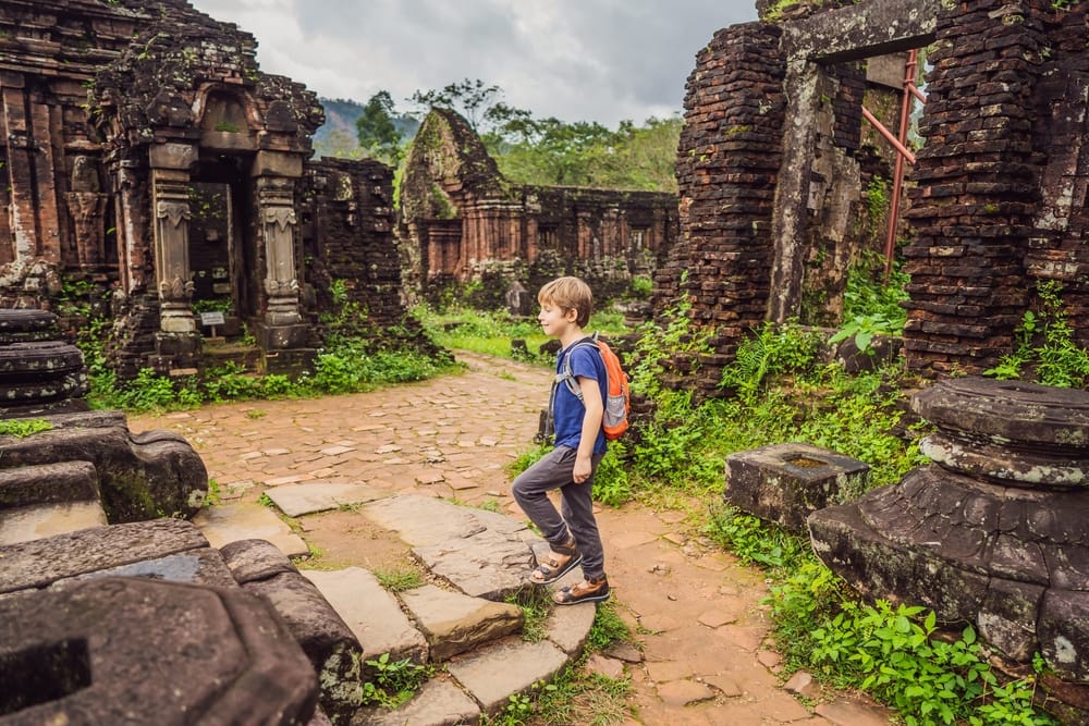Dreng udforsker tempelruinerne i My Son, Vietnams UNESCO-verdensarvsområde med gamle Champa-tårne