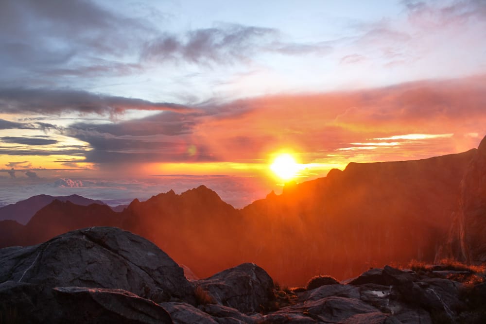 Solens første stråler farver himlen over Mount Kinabalu – et magisk øjeblik på Borneos højeste punkt, hvor naturens storhed føles helt tæt på.