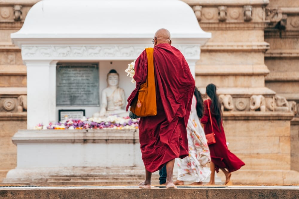 Buddhistisk munk går gennem det historiske tempelområde i Anuradhapura, Sri Lanka, i morgenen.