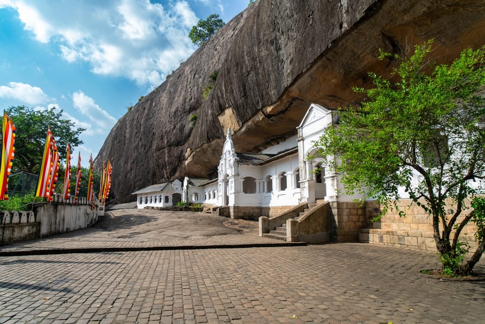 Udsigt over Dambulla Cave Temple, også kendt som Golden Temple of Dambulla, beliggende på en klippe omgivet af frodig natur.