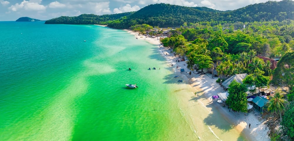 Luftfoto af Khem Beach på Phu Quoc Island med hvidt sand, turkisblåt hav og frodig tropisk kystlinje