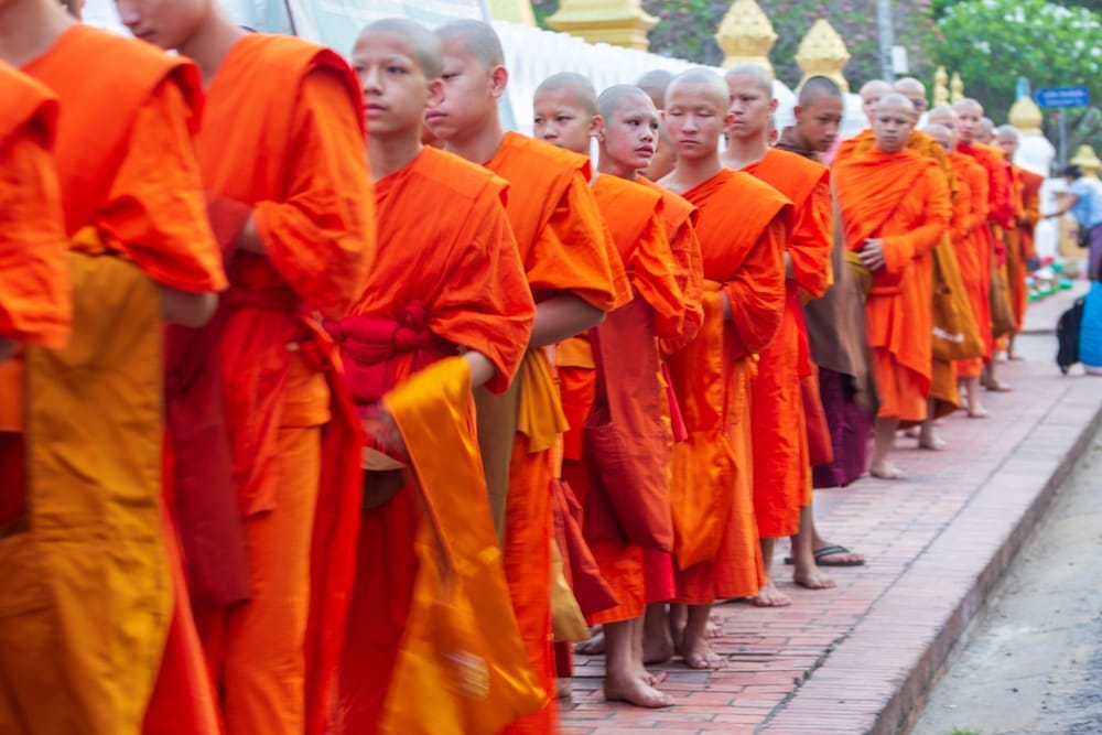 Buddhistiske munke i Luang Prabang modtager almisser under Tak Bat-ceremonien ved daggry