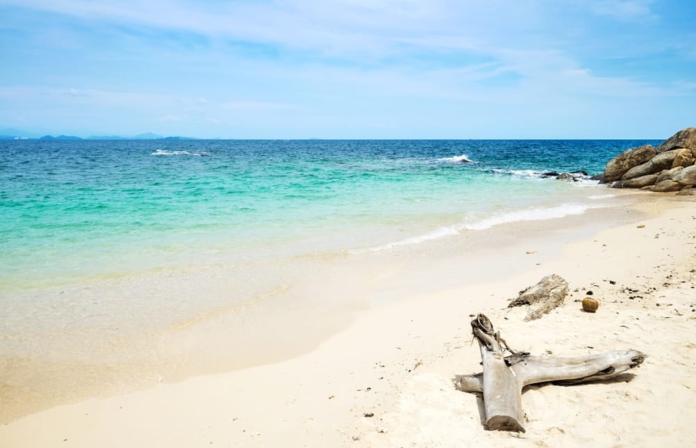 Den idylliske strand på Mamutic Island byder på krystalklart vand og hvidt sand omgivet af grønne palmer – et tropisk paradis i Tunku Abdul Rahman Nationalpark ud for Sabah.