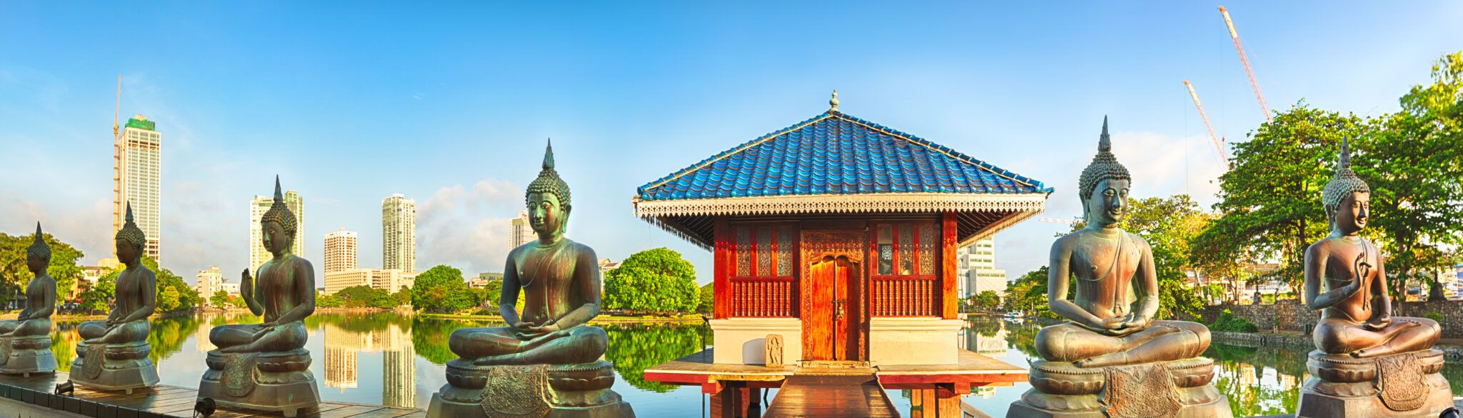 Seema Malaka-templet på Beira Lake i Colombo med pavilloner, vand og byens skyline i baggrunden.