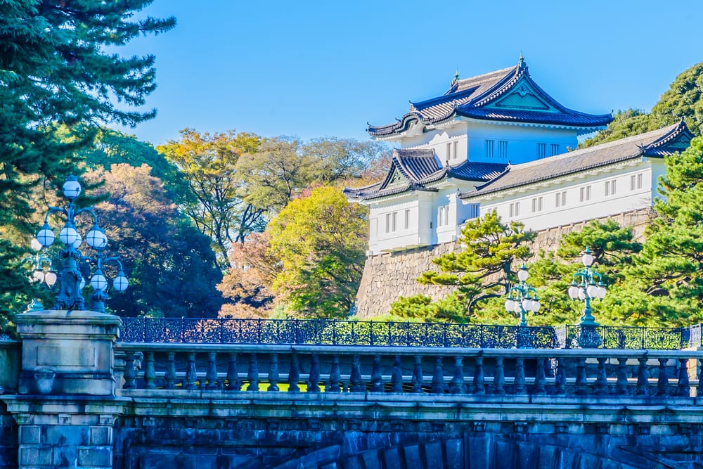 Det kejserlige palads i Tokyo omgivet af grønne haver, stenvægge og den rolige slotsgrav.