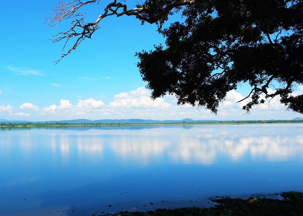 Stor sø ved Polonnaruwa i Sri Lanka omgivet af fladt landskab og historiske omgivelser.