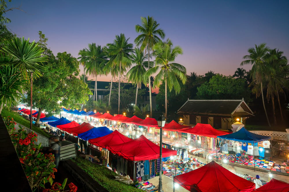 Natmarked foran Nationalmuseet i Luang Prabang med farverige boder, lamper og håndlavede varer