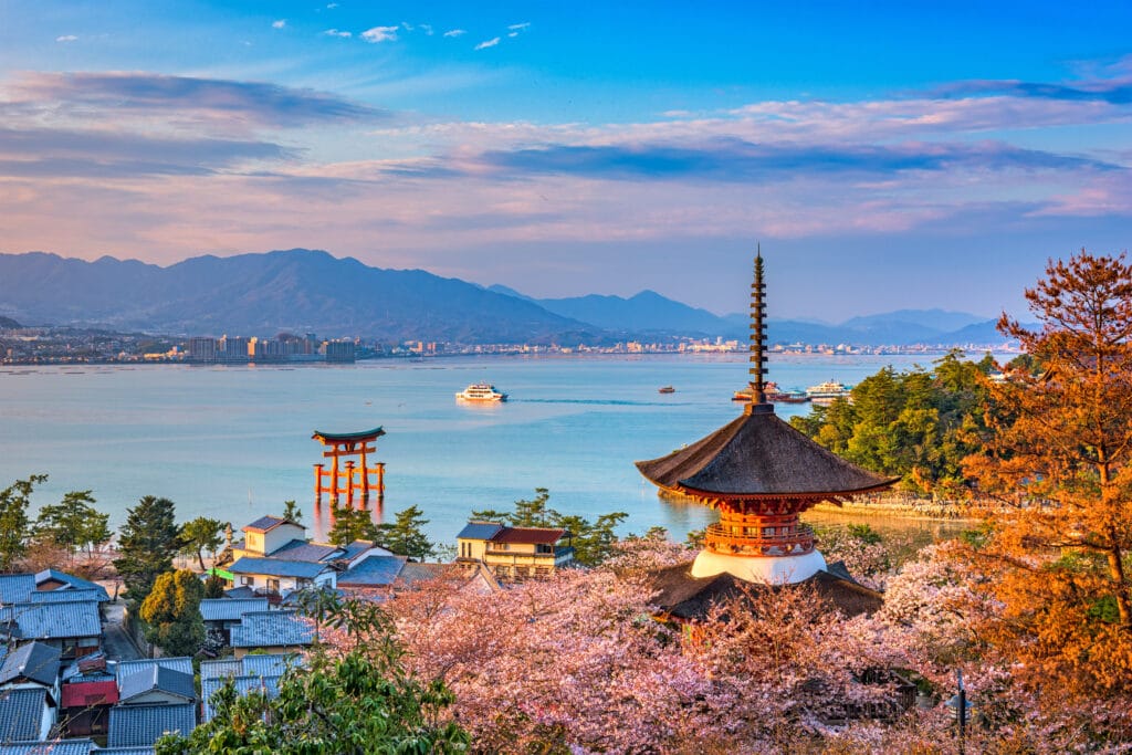 Miyajima Island i Hiroshima om foråret med kirsebærblomster og udsigt til den ikoniske torii-port ved Itsukushima-helligdommen.