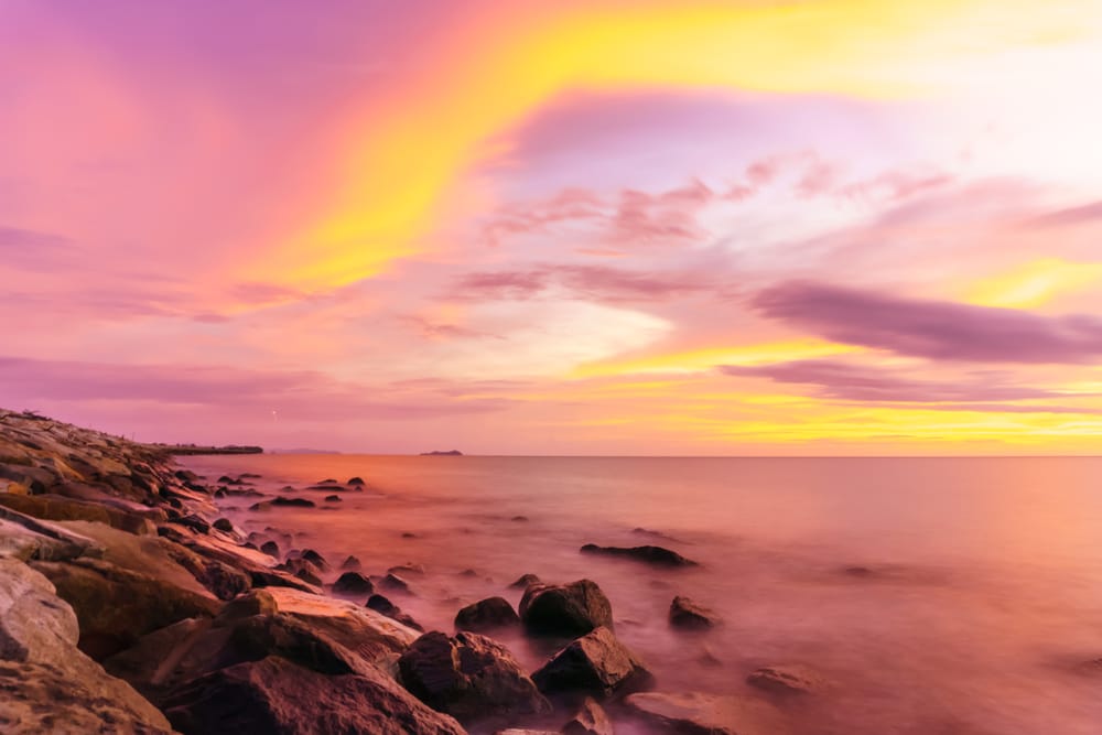 Smuk solnedgang ved Tanjung Aru Beach i Sabah, Malaysia.