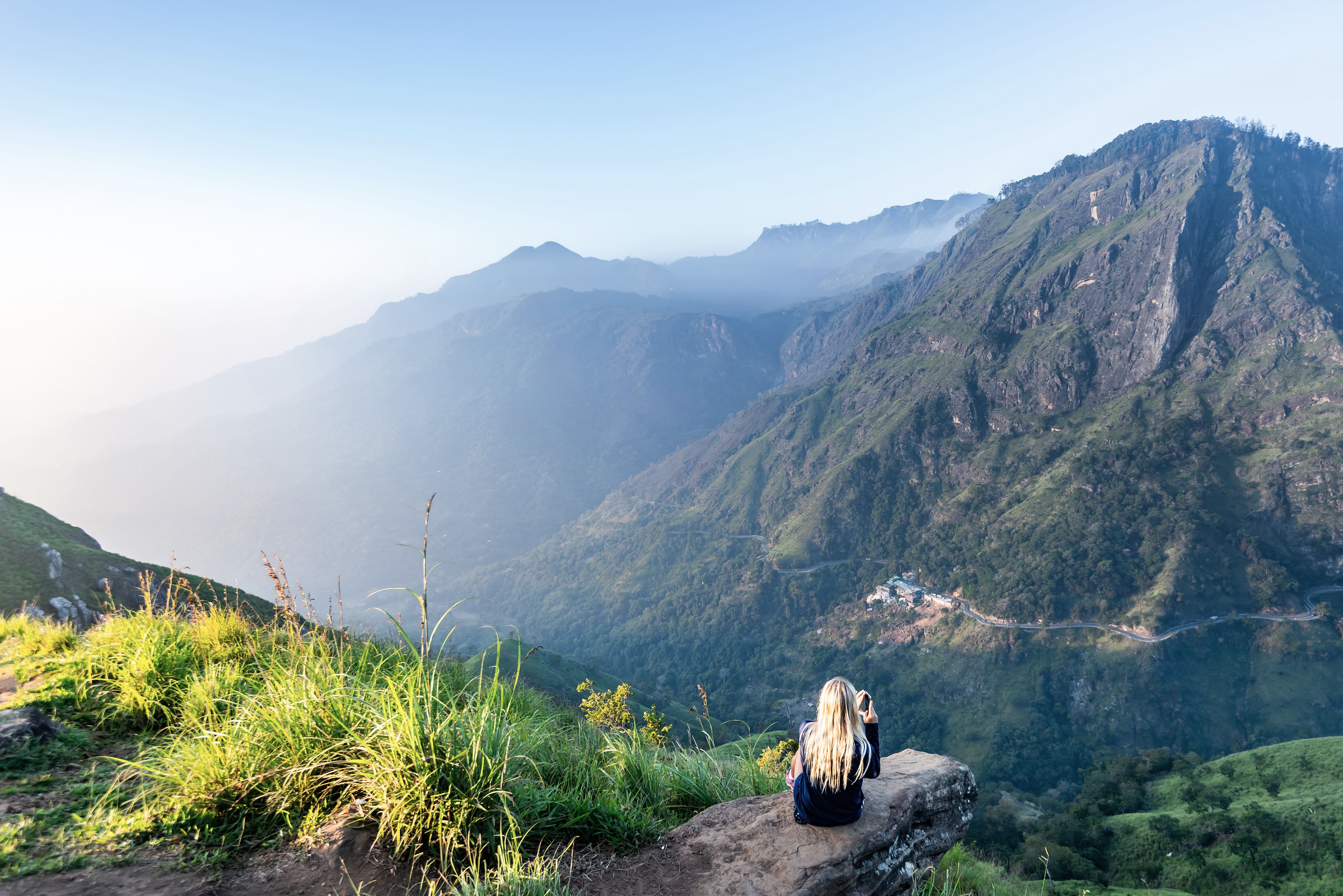 Udsigt fra Mini Adam’s Peak i Ella med grønne bjerge, dybe dale og tågedis i det srilankanske højland.