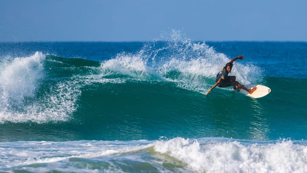 Surfer i bølgerne ved Ahangama på Sri Lankas sydkyst med Det Indiske Ocean i baggrunden.