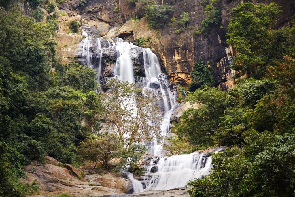 Højt vandfald ved Ravana Falls nær Ella i Sri Lanka omgivet af grøn tropisk natur.